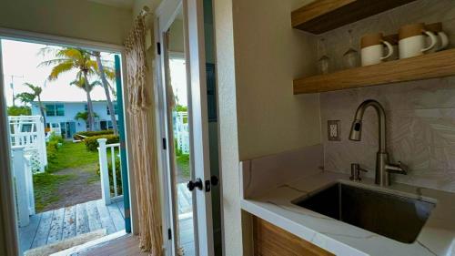 uma cozinha com um lavatório e vista para um quintal em Seahorse Beach Bungalows em Fort Pierce