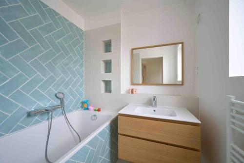 une salle de bain avec une baignoire, un lavabo et un miroir dans l'établissement Marais - Parents Suite & Kids Room with Park View, à Paris