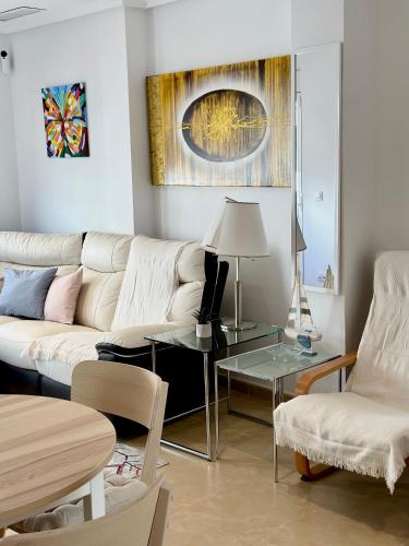 ein Wohnzimmer mit einem Sofa und einem Tisch in der Unterkunft San Pedro con ascensor y recogida in Santa Pola