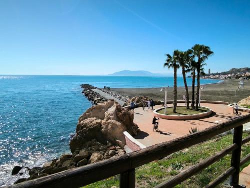 Blick auf einen Strand mit Palmen und das Meer in der Unterkunft El sueño de Noctiluca in Rincón de la Victoria