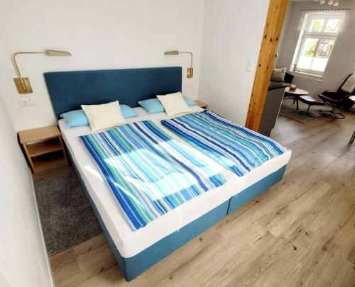 ザスニッツにあるFerienwohnung-2-in-der-Altstadt-Fam-Harderの青いヘッドボード付きの大型ベッド1台が備わる客室です。