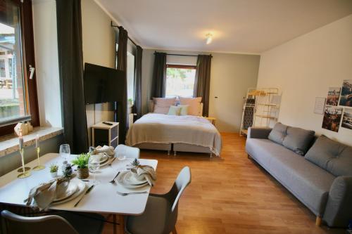 uma sala de estar com uma mesa, uma cama e um sofá em Hygge Homes - 1BR Apartment inkl. TV und Küche em Rosengarten