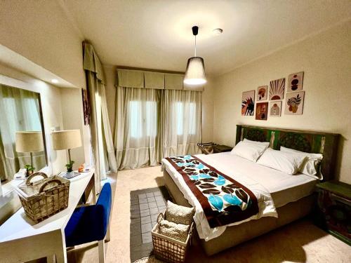 a bedroom with a large bed with a desk and a bed sidx sidx sidx sidx at Azzura appartment sahl hashesh with private garden in Hurghada