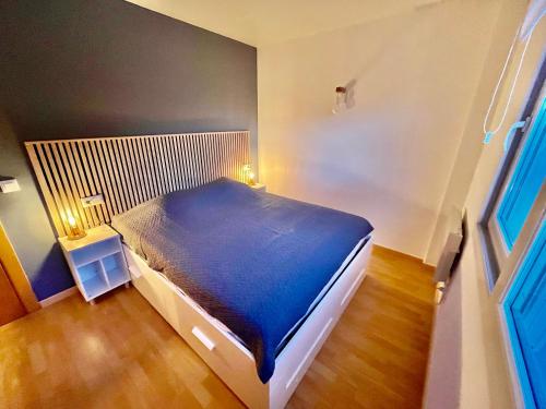 - une chambre avec un lit bleu dans l'établissement Superbe appartement rénové, résidence avec piscine, à Roses