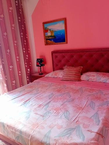 a pink bedroom with a bed with a red headboard at Guest House Cinderella in Herceg-Novi