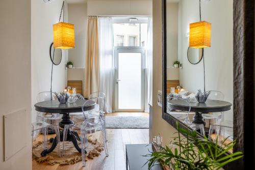 a dining room with two tables and a mirror at Duomo 9 - Luxury Modern Loft in Milan