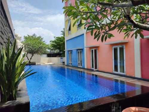 a swimming pool in front of a building at Front One Hotel Purwodadi in Purwodadi