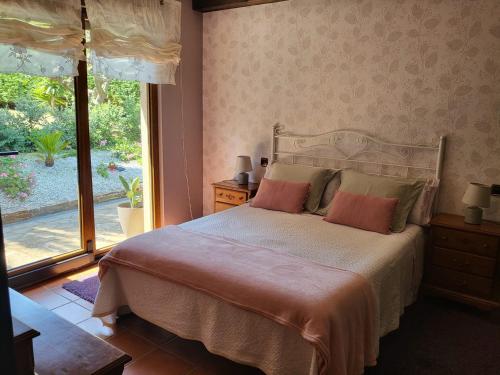 ein Schlafzimmer mit einem Bett und einem großen Fenster in der Unterkunft El rincón de Mónica in A Coruña