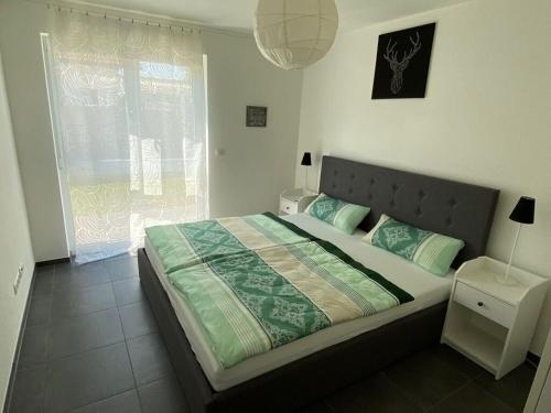 um quarto com uma cama grande num quarto com uma janela em Holiday apartment meadow em Sulzburg