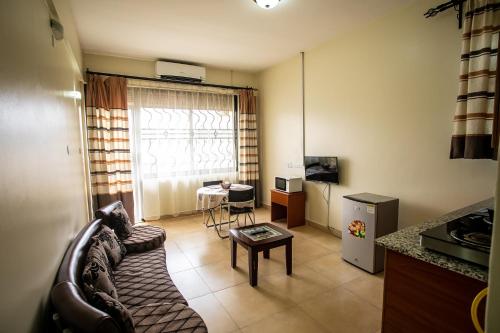 a living room with a couch and a table at ST STEVENS SUITES, ENTEBBE in Entebbe