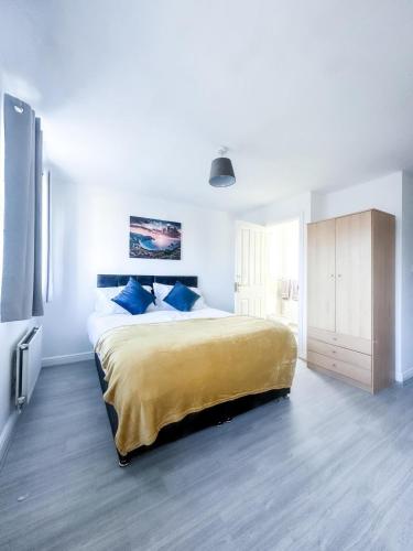 a bedroom with a large bed with blue pillows at Spacious 6 Bedroom House Near City Centre in Birmingham
