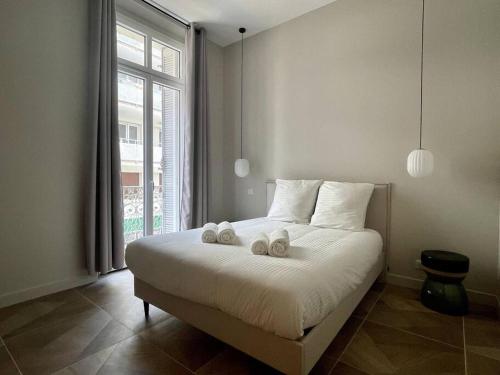 une chambre avec un lit avec deux animaux en peluche dessus dans l'établissement Appartement Centre Cannes, à Cannes