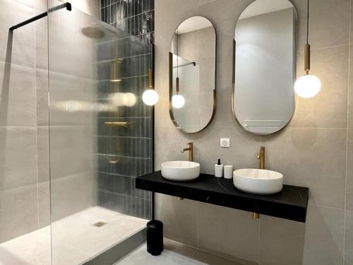 une salle de bain avec deux lavabos et deux miroirs dans l'établissement Appartement Centre Cannes, à Cannes