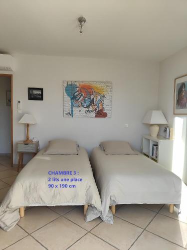 deux lits côte à côte dans une chambre dans l'établissement Villa BRIMI, à Ghisonaccia