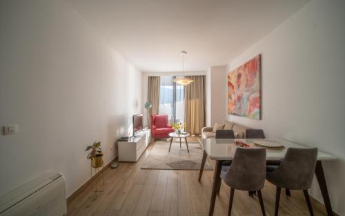 Amare Luxury Apartments في بودفا: غرفة معيشة مع طاولة وكراسي