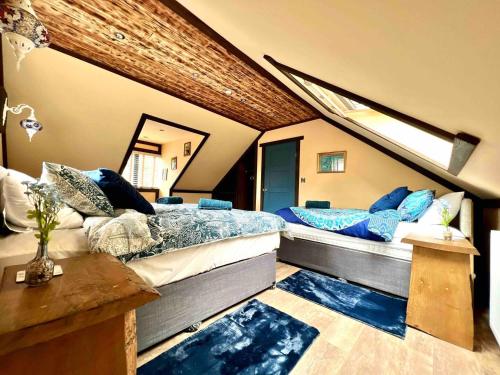 a bedroom with two beds with blue pillows on them at Re-Vive, At Rhigos, ZipWorld,Pen-y-Fan,Waterfalls in Pont-Nedd-Fechan