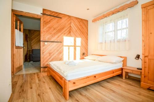 um quarto com uma cama e uma parede de madeira em Apartament 33 Poronin em Poronin