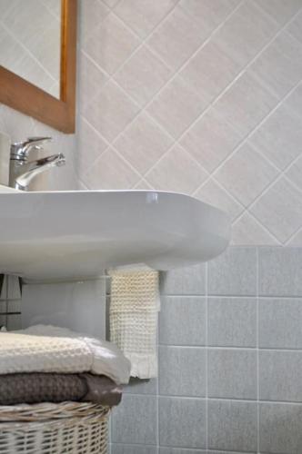 a bathroom with a sink and a mirror and towels at Appartamento Nara in Pietrasanta