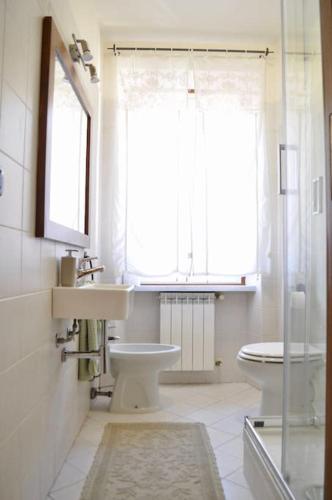 a bathroom with a sink and a toilet and a window at Appartamento Nara in Pietrasanta