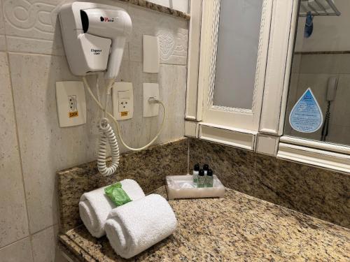 uma casa de banho com um lavatório e um secador de cabelo no balcão em IL Campanario é Destino Floripa em Florianópolis