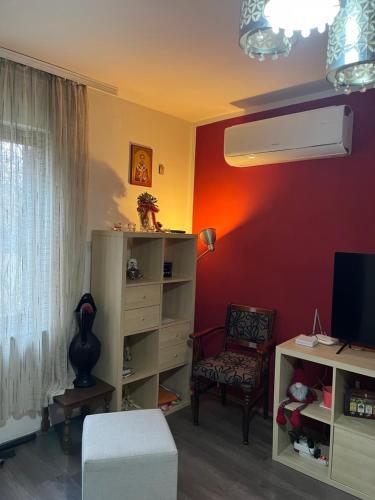 un soggiorno con una parete rossa e una sedia di Apartmani Vlaška a Vlaška