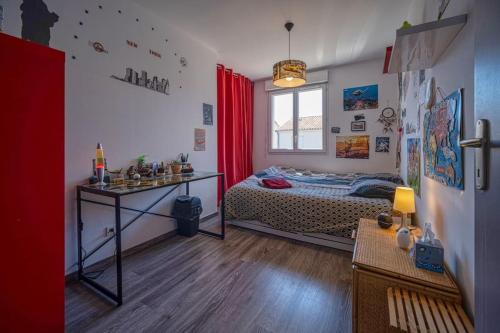 une chambre avec un lit, une table et une fenêtre dans l'établissement Charmante maison de Lotissement, 6 couchages, à Portes-lès-Valence