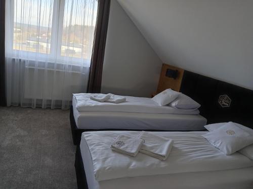 two beds in a hotel room with towels on them at Karczma u Jana in Kuczów