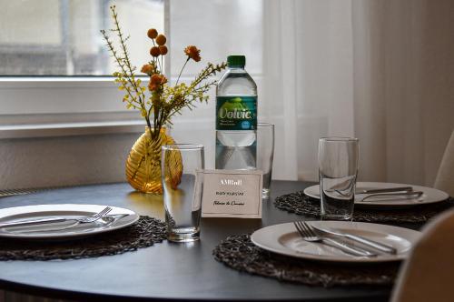 einen Tisch mit Tellern und eine Flasche Wasser darauf in der Unterkunft Deluxe! Hbf-Nähe mit Kingsize-Bett, 65 m2 in Duisburg