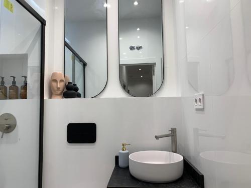 uma casa de banho branca com uma banheira e um lavatório em Valencia beach rooms em Valência