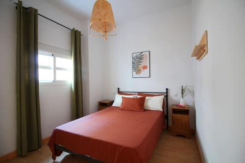 a bedroom with a bed with red sheets and a window at Sevilla centro- Sol - Acogedor y luminoso in Seville