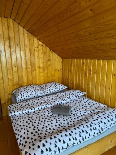 a bedroom with a bed in a wooden room at Panoramic House in Mărişel