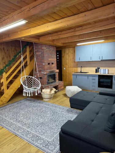 a living room with a couch and a kitchen at Panoramic House in Mărişel