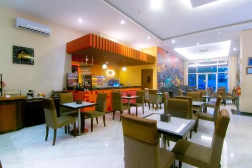 a dining room with tables and chairs in a restaurant at Front One Hotel Purwodadi in Purwodadi