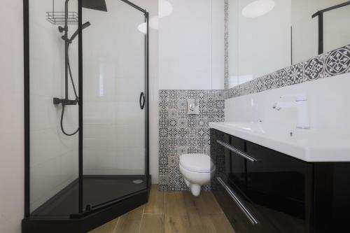 a bathroom with a toilet and a glass shower at Toscany de LUX samo centrum in Bielsko-Biała
