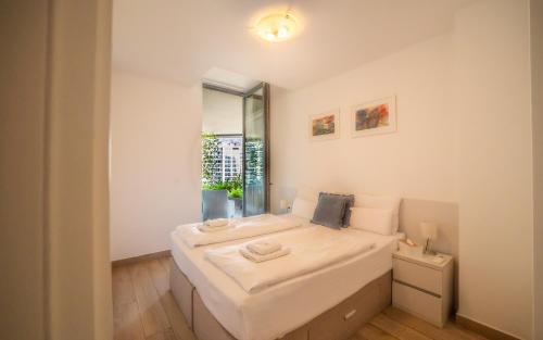 a room with a large white bed with a window at Amare Luxury Apartments in Budva