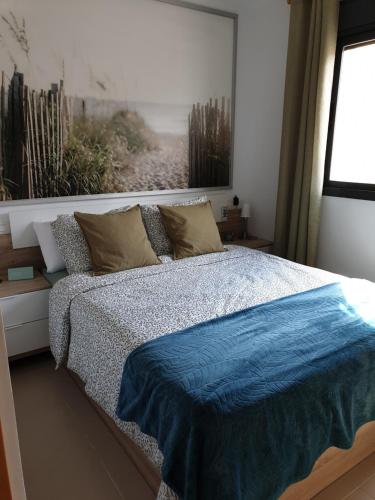 ein Schlafzimmer mit einem Bett mit einer blauen Decke darauf in der Unterkunft Enjoy the beach in Bellreguart