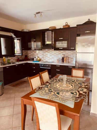 a kitchen with a table and chairs and a kitchen with a refrigerator at Villa Athamanio - Premium in Athamanio