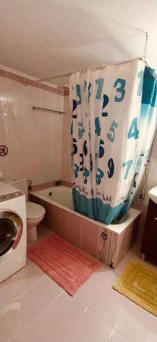 a bathroom with a toilet and a tub with a shower curtain at Villa Athamanio - Premium in Athamanio