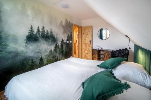 a bedroom with a large white bed with green pillows at Karkonoskie Zacisze in Mysłakowice