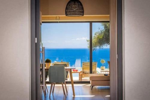 a dining room with a view of the ocean at Olive Zen Villa Zante with Private Pool & Sunrise Sea View in Zakynthos