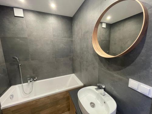 a bathroom with a sink and a toilet and a mirror at Szpakowa Luxury Apartment in Kraków