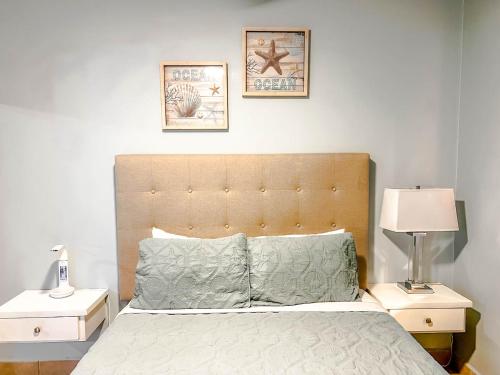 ein Schlafzimmer mit einem Bett mit zwei Nachttischen und zwei Bildern an der Wand in der Unterkunft Princesa de Penasco Condo B303 Sandy Beach Puerto Penasco in Puerto Peñasco