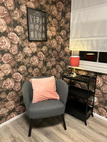 a chair with an orange pillow sitting in front of a wall at Ferienwohnung Saargauliebe in Saarburg