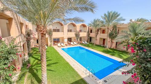 an aerial view of a villa with a swimming pool and palm trees at Gemma Resort in Marsa Alam City