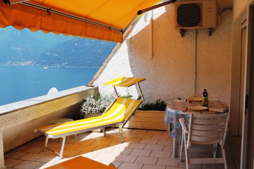 ルイーノにあるTerrazza sul Lagoのテーブルと椅子、水辺の景色を望むバルコニー