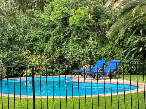 2 sillas azules sentadas junto a una piscina en Casa en San Isidro en San Isidro