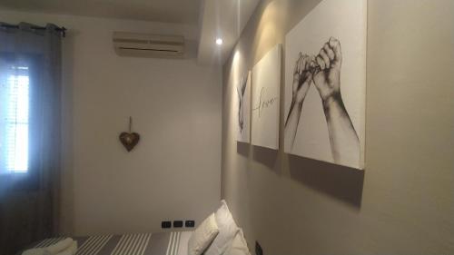 une chambre avec des photos des mains sur un mur dans l'établissement Golfo Asinara Suite guest house con vasca idromassaggio R4976, à Sorso