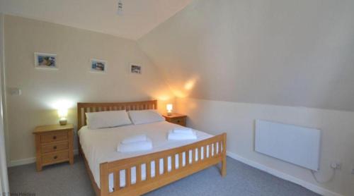 a bedroom with a large bed and two night stands at 36 Tudor Court, Tolroy Manor in Saint Erth