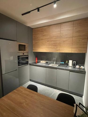 a kitchen with a table and a sink and cabinets at Leo Lux 2 in Niš