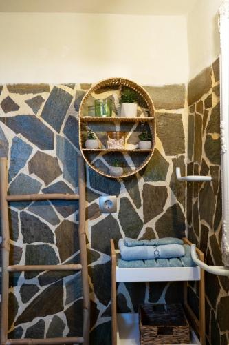 a bathroom with a stone wall with a mirror and towels at Jutta's house in Kallithéa